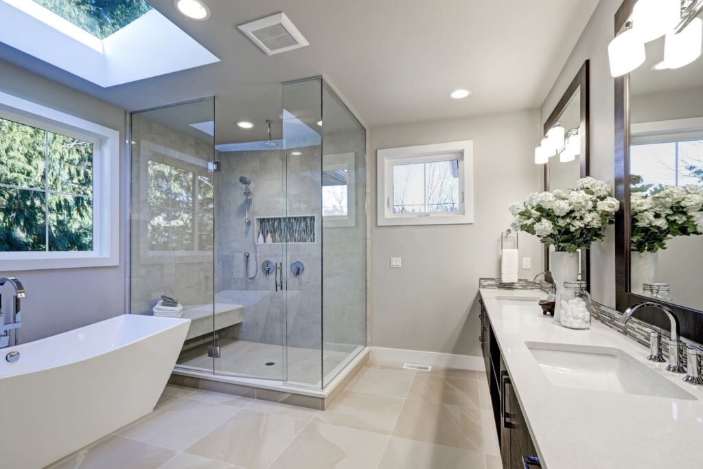 A clean bathroom with a large shower and sink, featuring glass door installation and exterior bifold glass door